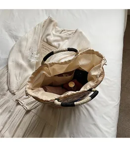 Top-down shot of straw tote bag interior showing large capacity and drawstring liner