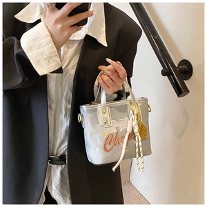 Détail du sac à main argenté métallisé avec imprimé Ch orange et clous dorés