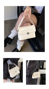 Detail of a creamy white oil wax leather handbag featuring a round silver metal buckle