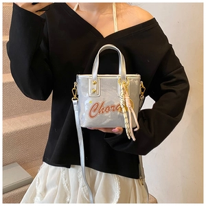 Détail du mini sac argenté métallisé avec lettrage Chora et breloque en corde tressée