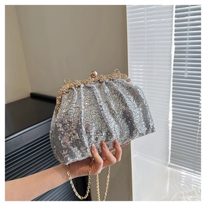 Gros plan d'un sac de soirée à paillettes argentées avec fermoir doré et chaîne