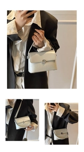 Detailed view of cream minimalist small square bag with silver metal buckle and top handle