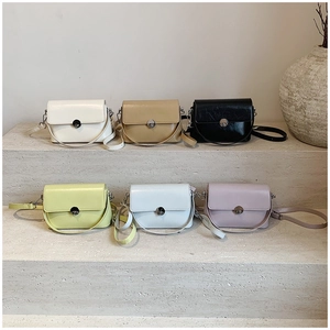 Detailed display of six colorful minimalist oil wax leather crossbody bags on stone steps