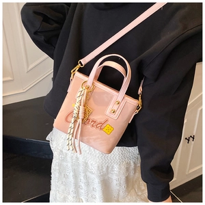 Sac seau rose avec imprimé lettres et fleurs porté par un mannequin avec jupe