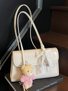 Borsa a spalla bianco crema lucida con fiocco in pizzo e ciondolo a forma di orsetto