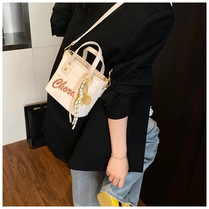 Détail du sac seau crème avec lettrage Chora et accessoires tissés très élégants