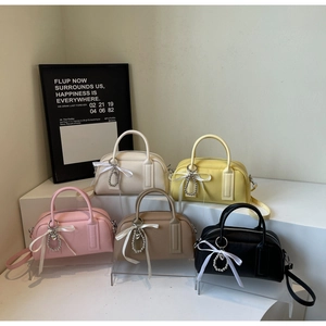 Group display of five Boston bags in litchi grain leather with ribbon and heart charms