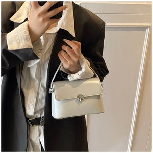Close-up of white oil wax leather square handbag featuring a silver twist lock closure