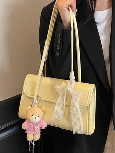 Borsa a spalla in ecopelle giallo crema con ciondolo a forma di orsetto e stile minimal