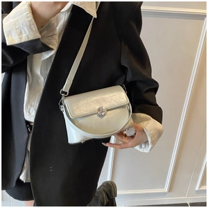 Detailed shot of pearl white leather crossbody bag with silver circular metal lock