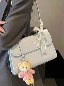 Borsa a spalla minimalista azzurro chiaro con ciondolo a orsetto e fiocco in pizzo