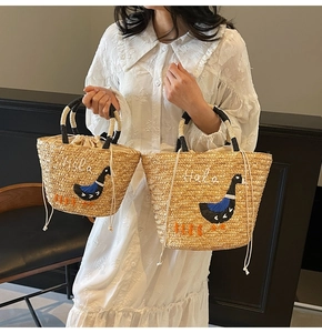 Detail of straw tote bags with Hola embroidery and drawstring inner bags in two sizes