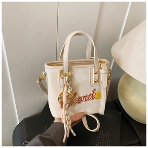 Détail du sac seau blanc cassé avec broderie rouge et pendentif arc-en-ciel coloré