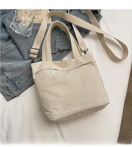 Detail showing soft canvas fabric and adjustable strap of the minimalist beige crossbody bag