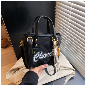 Détail du sac seau noir avec imprimé Chord, bandoulière réglable et ferrures dorées