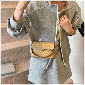 Close-up of khaki oil wax leather crossbody bag with silver twist lock and shoulder strap