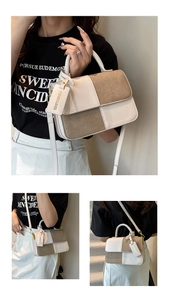 Detailed view of bicolor patchwork crossbody bag with elegant handle and fashion tag