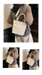 Detail of off-white tote bag showing crinkled texture fabric and detachable wide strap
