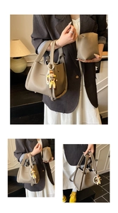 Dettaglio della borsa shopper in pelle grigia con scritta fashion e ciondolo di perla