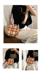 Detail of checkered plaid canvas shoulder bag with round button closure and wide strap