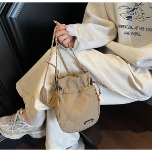 Detail view of khaki nylon bucket bag showing drawstring closure and black Lucky label