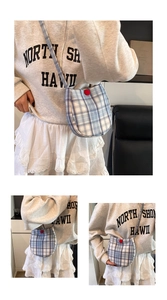 Detail of blue plaid crossbody bag with a red button closure shown from various angles