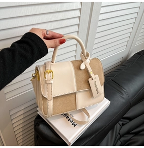 Detailed close-up of a contrast checkered handbag with premium metal buckle and leather handle