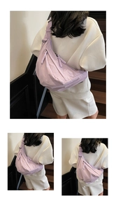 Detail view of light purple nylon crescent bag with rope zipper pull and adjustable strap