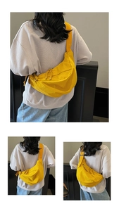 Detail view of bright yellow nylon crescent bag featuring sturdy dual woven zippers