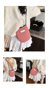 Detail of red and white checkered fabric bag with brand label and textured strap