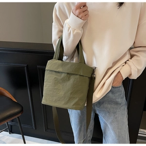 Detail of army green nylon crossbody bag with adjustable strap and textured surface