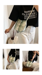 Detail view showing vintage green plaid fabric texture and blue button on crossbody bag