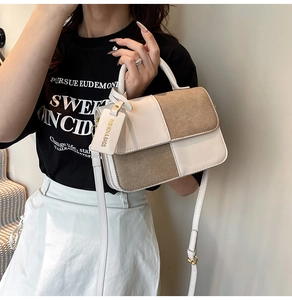 Close-up of contrast checkerboard bag showing mix of off-white leather and khaki suede