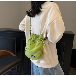 Detail of lime green drawstring bag with LUCKY label and woven shoulder strap