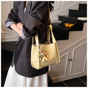 Detail showing litchi texture leather bucket bag with fashion charm and pearl chain