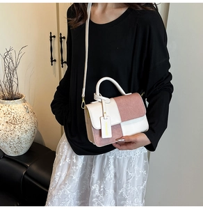 Detail view of pink and white patchwork handbag with adjustable strap on a model