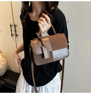 Close-up of brown patchwork leather handbag featuring a metal lock and round handle