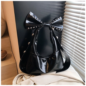 Detail der schwarzen Lackleder-Schultertasche mit Nieten und großem Schleifen-Design