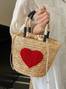 Handmade woven straw beach bag with red crochet heart and black-white handles