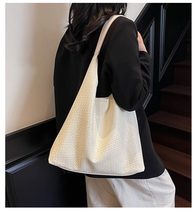 Detail of cream woven hobo bag showing the rich texture on a modern fashion model