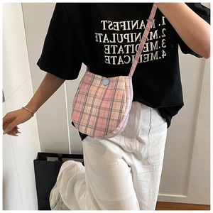 Detail view of the pink plaid fabric crossbody bag shown on a model for daily styling