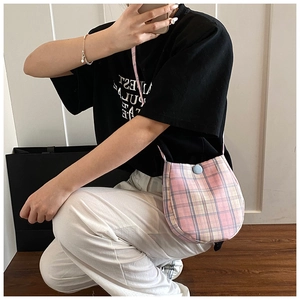 Detail of pink plaid crossbody bag with light blue button and soft canvas texture