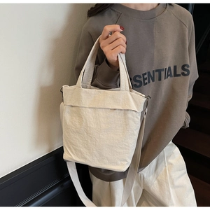 Close-up of cream canvas tote bag with crinkled texture and adjustable shoulder strap