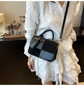 Detail of black crossbody bag with mixed leather and suede texture and chain detail