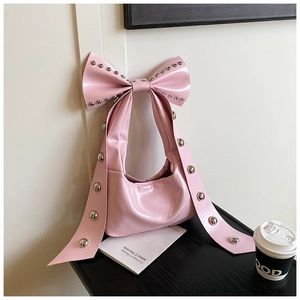 Detail der pinkfarbenen Lackledertasche mit Nieten und einzigartigem Schleifengurt