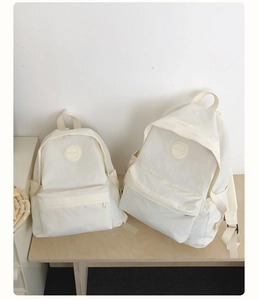 Vergelijking van grote en kleine witte nylon rugzakken met een strak minimalistisch design