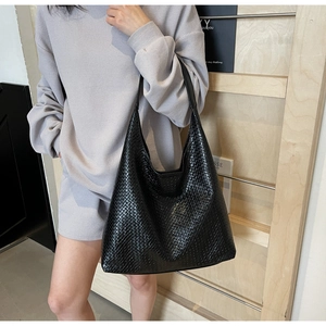 Detail of black woven texture on a large hobo tote bag with a seamless shoulder strap