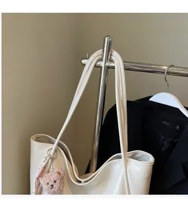 Creamy white oil wax leather tote bag featuring thin straps and a cute brown plush bear charm
