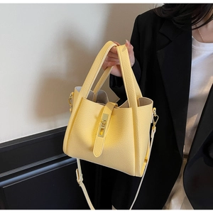 Détail du sac seau en cuir jaune clair avec grain de litchi et fermoir doré élégant