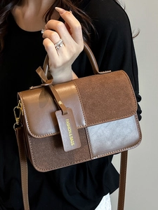 Brown patchwork leather handbag with top handle and strap shown by model